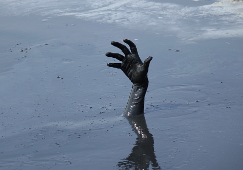 Drowning hand in mud